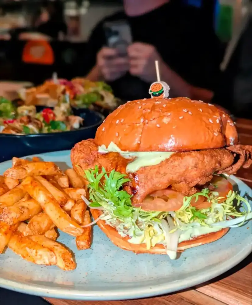 A crumbed fish burger with chips and slaw