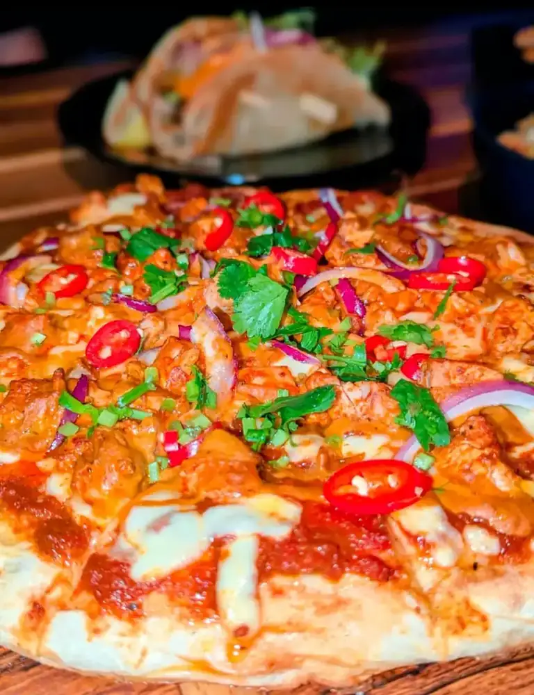 A close-up of the chicken naanzza with chilli and coriander