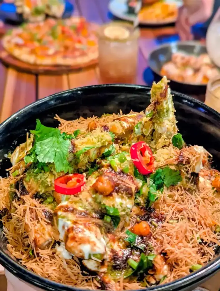 A rice bowl topped with chicken, chilli and fresh herbs
