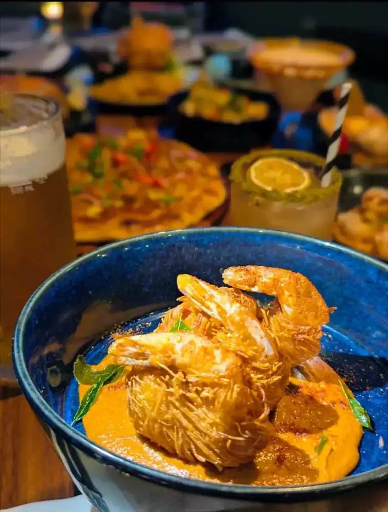 Golden prawns in a creamy sauce, served in a dark bowl