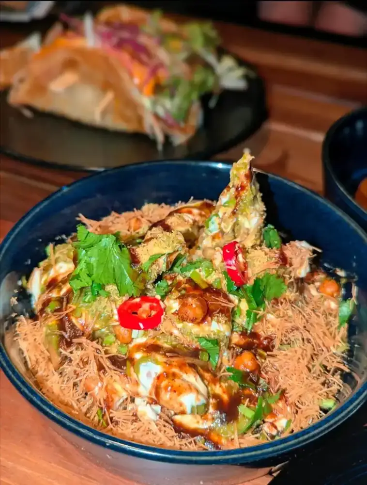 A loaded rice bowl with chicken, herbs and fresh chilli