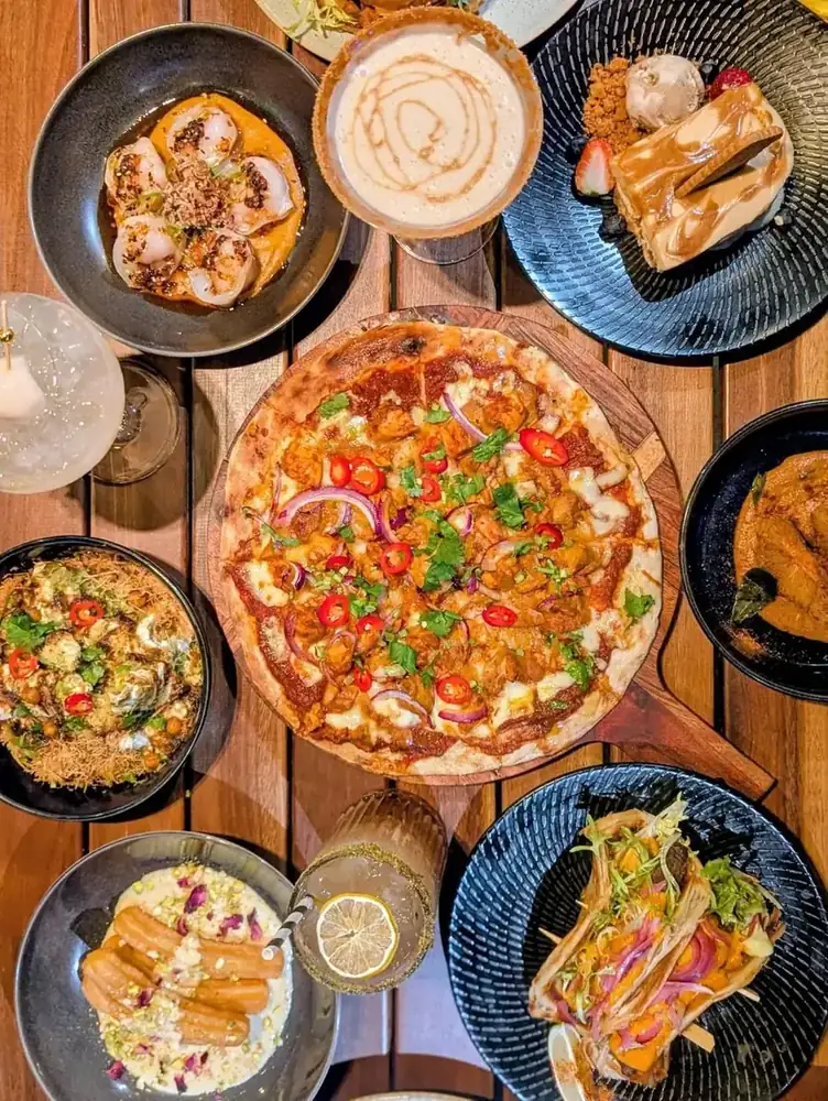 A table of Forktales share plates and pizza, seen from above