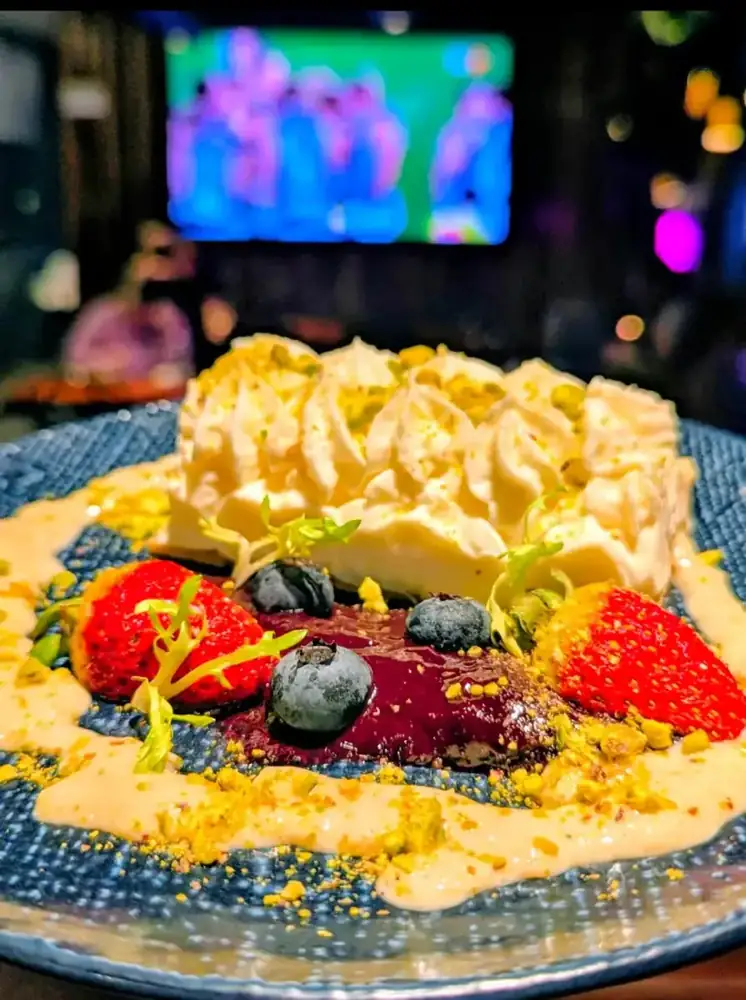 A dessert plate with berries, cream and crumb
