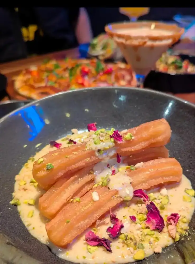 Churros dusted with pistachio and rose on a plate