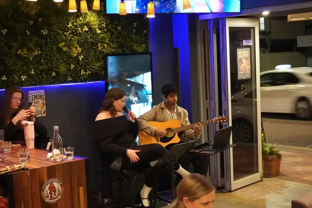 A duo playing live music by the open front of the restaurant