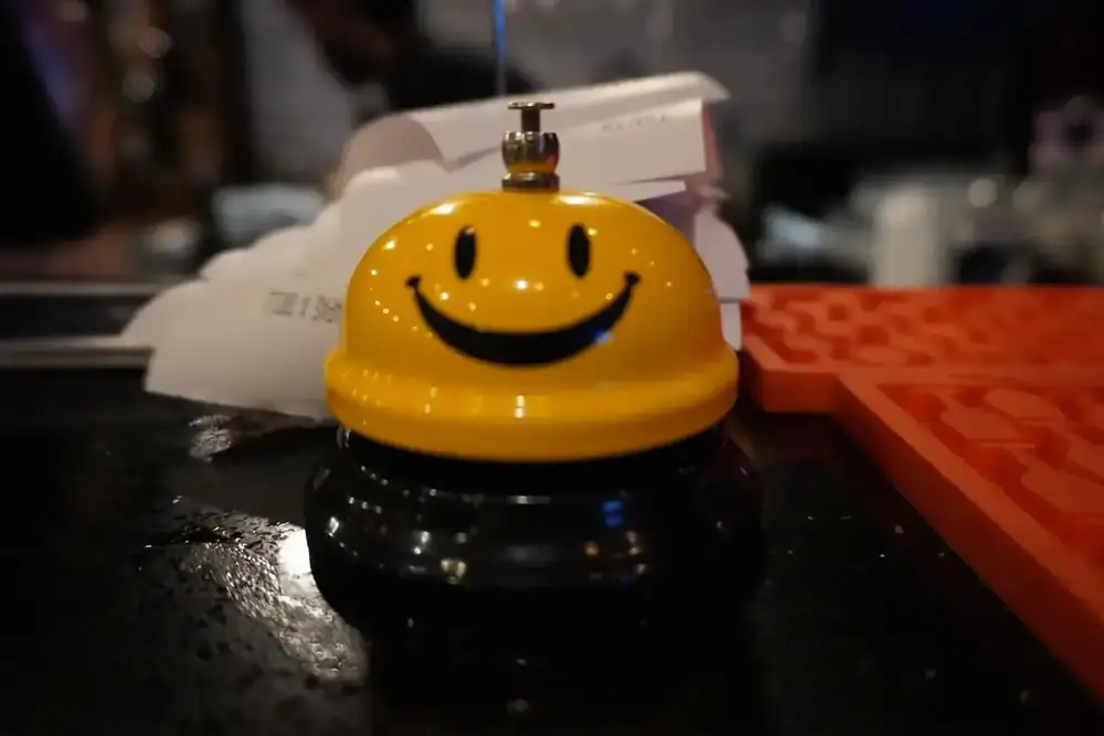 A yellow smiley service bell on the bar